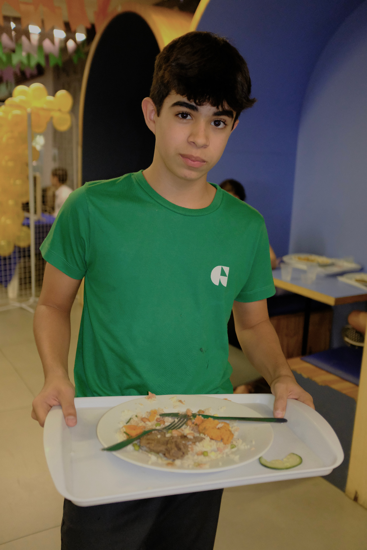 Aluno mostrando o prato após a refeição